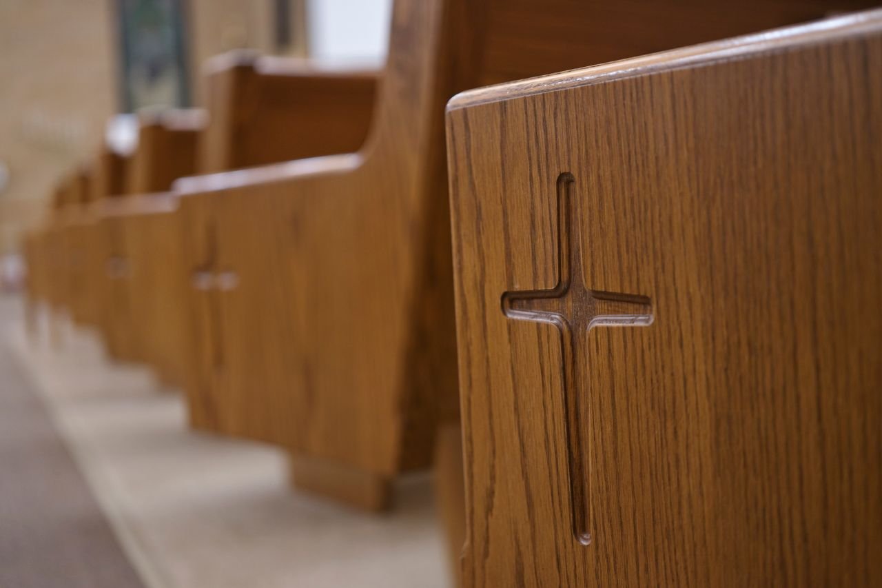 Mastering the First Impression: Your intriguing post title goes here Detailed view of wooden church pews with cross carvings in a Berlin, Wisconsin church.